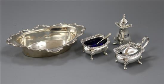 A three piece silver cruet set with one spoon and a silver bon bon dish